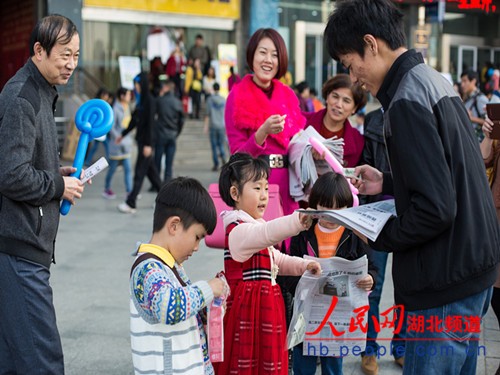 武汉一幼儿园孩子街头卖报 掰指头算数找零钱