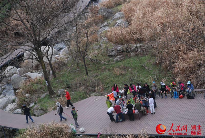 人民网麻城3月20日电 3月19日,国家4A景区湖北麻城龟峰山风景区迎来今春首个旅游小高峰,景区内多个景点车水马龙,来自武汉、河南、黄石等周边地区的游客一拨接一拨,络绎不绝。 笔者在景区月亮湾看到,一辆辆自驾车和旅游大巴有序的停放在广场上;在即将对外营业的龟峰峡谷里,不少老人、儿童在家人陪伴下畅游其中,与大自然亲密接触,其乐无穷;茶溪古镇和月亮湾的农家乐餐馆,游客们品着龟山岩绿,尝着新鲜的山野菜,真正体验生态游,乐在其中。(邱东旭 程胜利 摄)