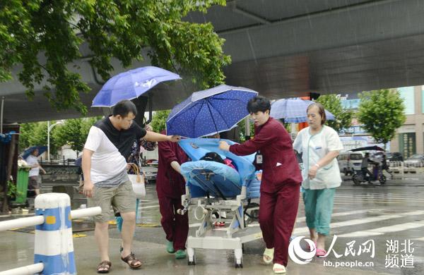武汉暴雨袭城 护士冒雨趟水救治早产破水孕妇