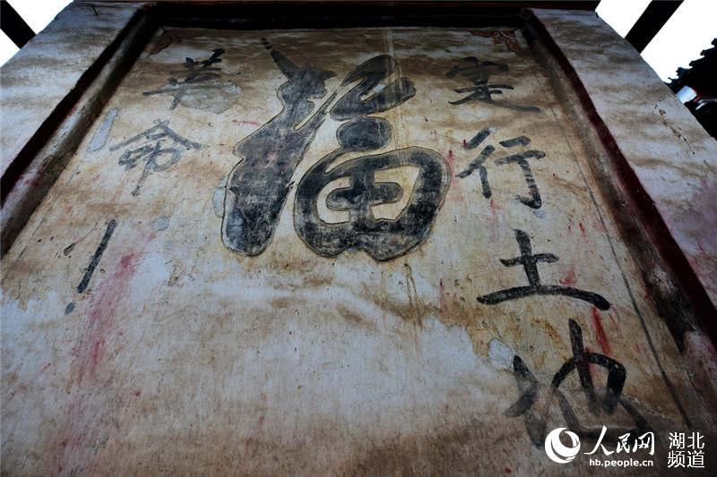 图为太子坡隐蔽墙正面福两旁书写的实行土地革命红军标语