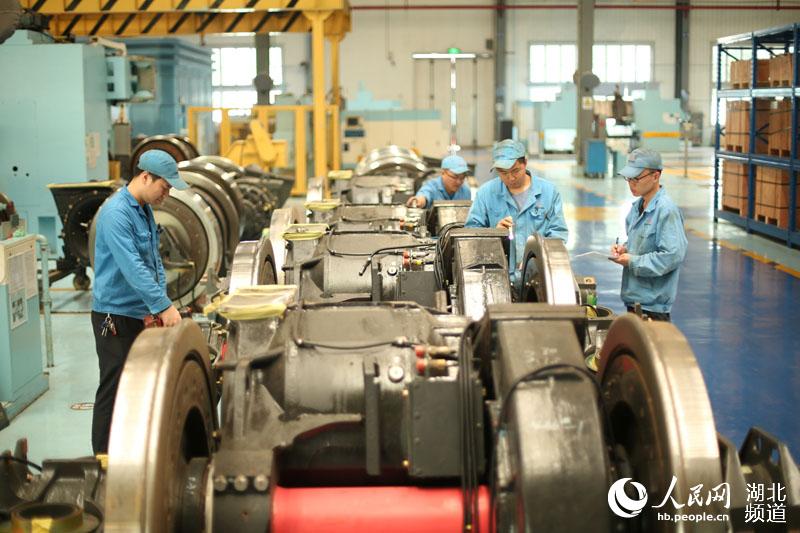 图为该段职工正在查验机车轮对驱动装置（廖超 摄）