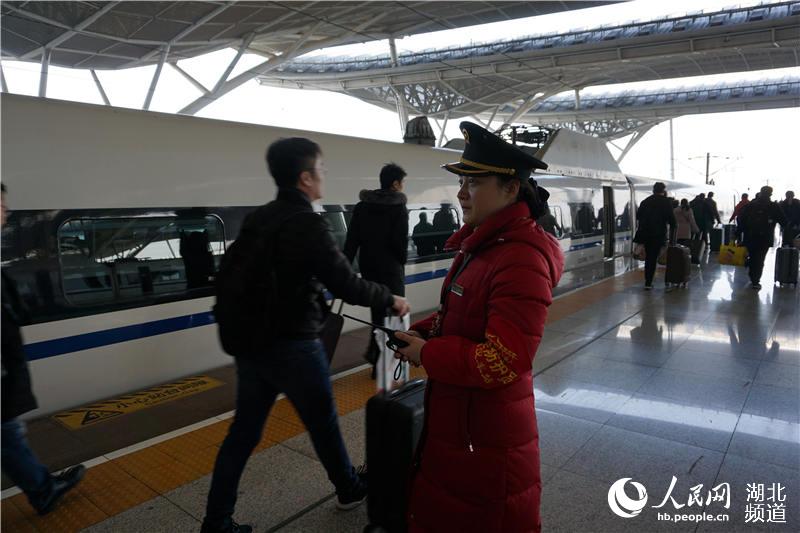 2018年1月24日上午，武漢火車站客運值班員程亞楠在上班時把女兒帶到車站來，交給同在火車站工作的丈夫施雷。春運來了，他們無法照顧放假在家的孩子，隻能把孩子送回西安老家。圖為程亞楠送完丈夫和女兒，回到自己的工作崗位。