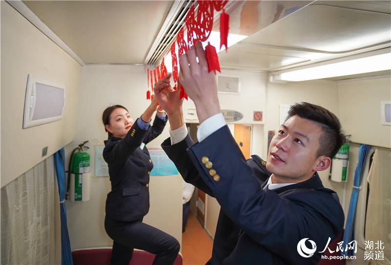 1月12日，列車工作人員布置車廂，為旅客營造溫馨喜慶的乘車環境。