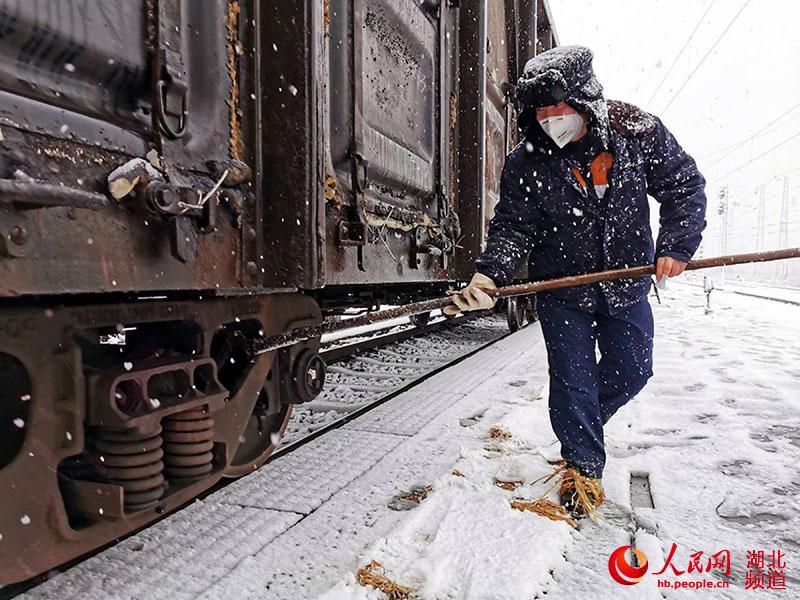 武漢北車站調車人員正在雪中進行列車編組作業。（溫昊 攝）