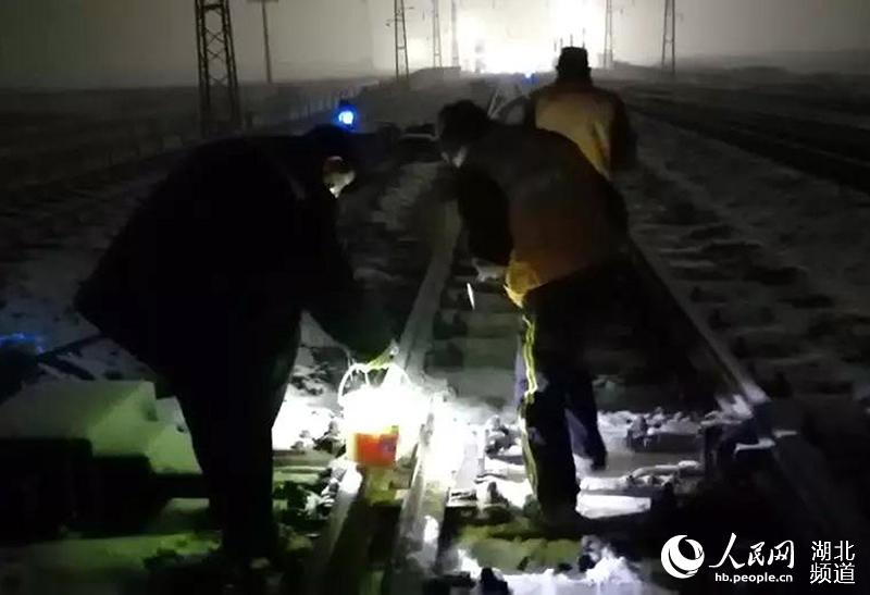 襄州北車站凌晨3點至5點冒雪對道岔進行清掃，涂抹除雪劑，確保浩吉鐵路的運輸暢通。（何勇 攝）