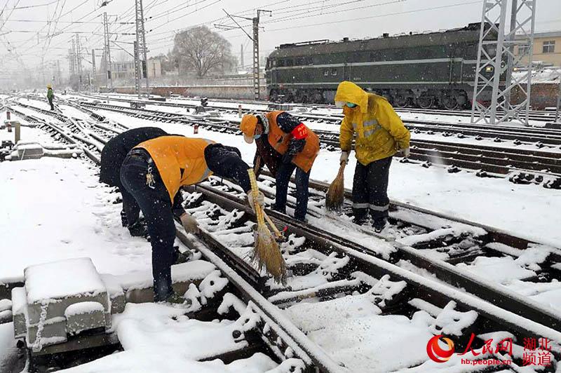 信陽電務段組織黨員突擊隊對道岔積雪進行清掃。（閆亞強 攝）