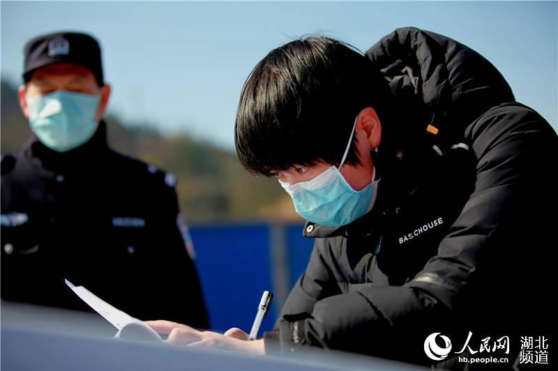 2月16日，在湖北省秭歸縣高速公路出入口，便衣女警王樂為進出車輛人員進行登記。