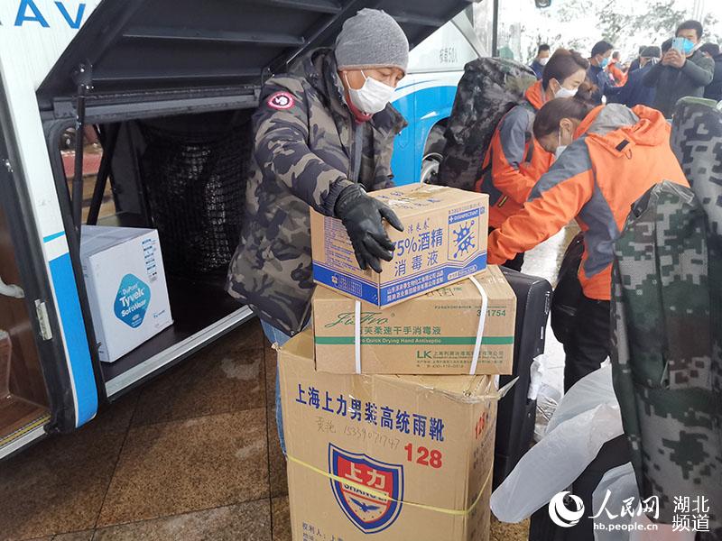 2月15日，駕駛員幫助西安醫療隊搬運行李物資