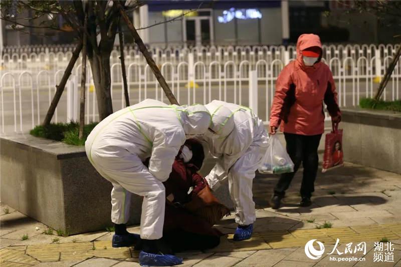 民警鄧雲鶴、李曉霖一左一右把病人慢慢攙扶坐起。(崔萌 攝)