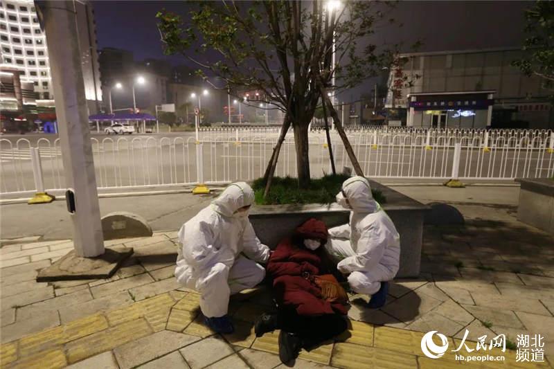 民警鄧雲鶴蹲下身子把自己的大腿當做“靠墊”支撐住病人。(崔萌 攝)