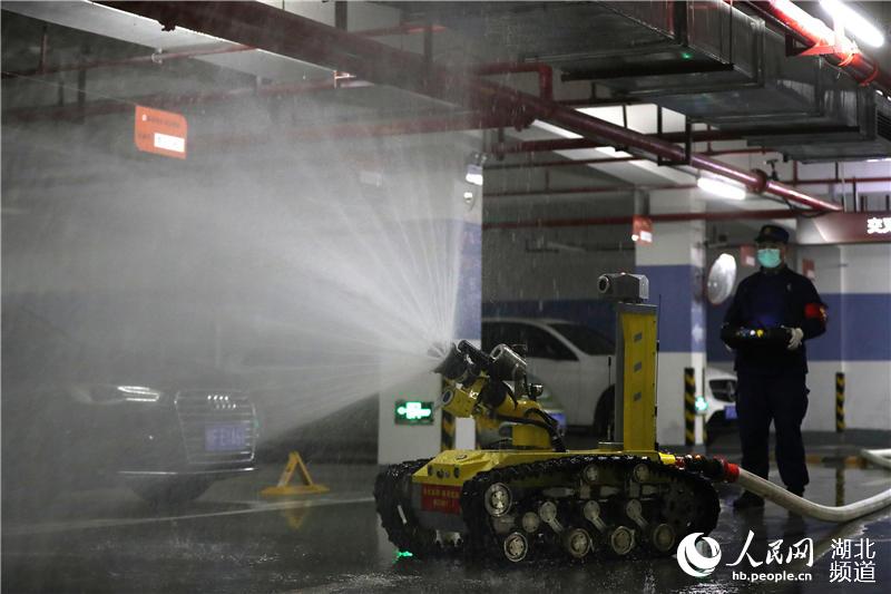 2020年3月1日，湖北省襄陽市消防指戰員使用消防機器人在襄城區一家小區地下停車場進行消毒作業。（楊東 蘇曉杰 攝）