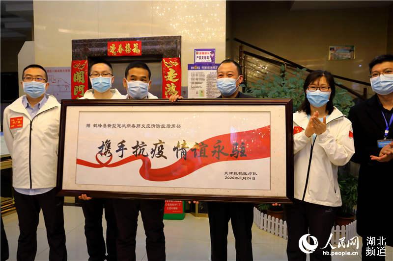 3月24日，天津市醫療隊向鶴峰縣贈送“攜手抗疫 情誼永駐”的牌匾。