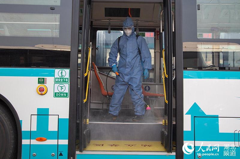 2020年3月25日，在湖北襄陽公交集團二公司停車場，工作人員對公交車進行噴洒消毒。楊東攝