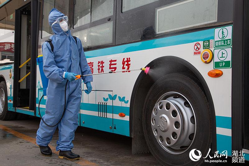 2020年3月25日，在湖北襄陽公交集團二公司停車場，工作人員對公交車進行噴洒消毒。楊東攝
