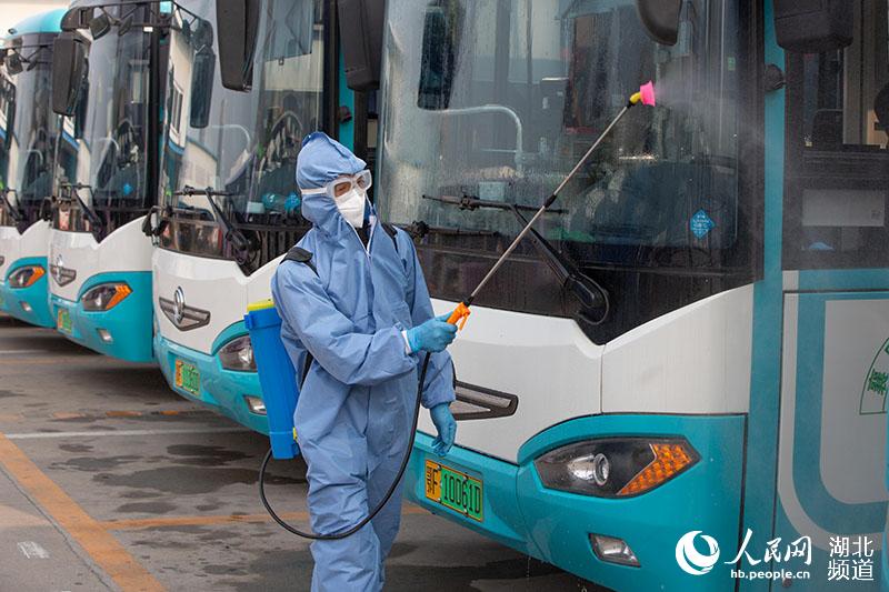 2020年3月25日，在湖北襄陽公交集團二公司停車場，工作人員對公交車進行噴洒消毒。楊東攝