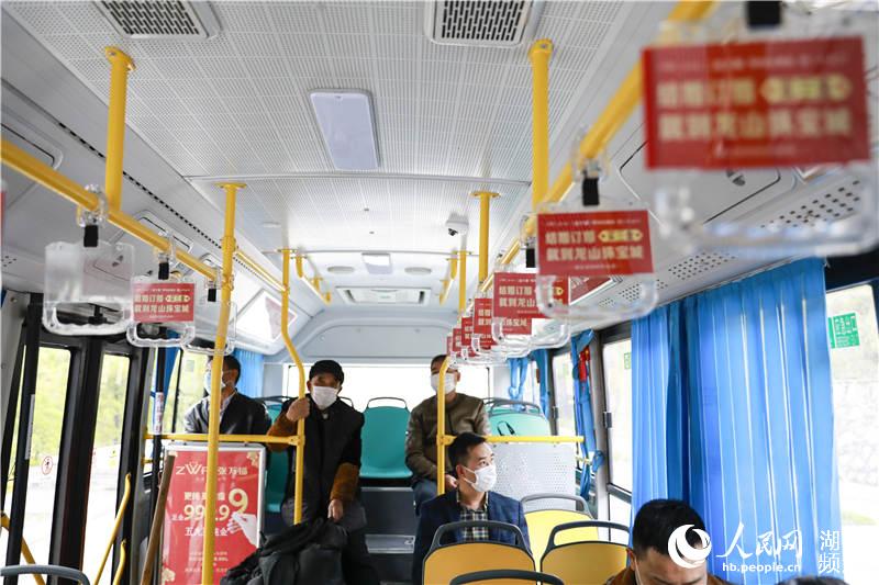 3月28日，在湖北來鳳和湖南龍山的跨省公交車上，乘客戴著口罩，隔座而坐。
