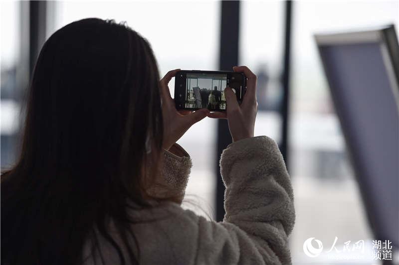 3月28日，乘坐G6860次列車的旅客通過手機記錄襄陽東高停站以來首次公開售票后旅客進站的瞬間。（施勇 攝）