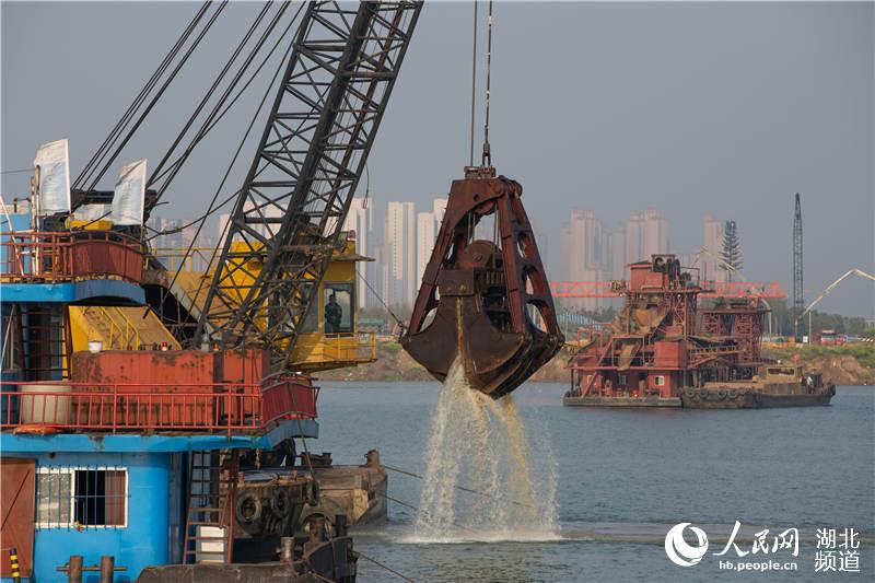 3月31日，施工人員操作機械在漢江上開挖沉管隧道江底基槽。（楊東 攝）