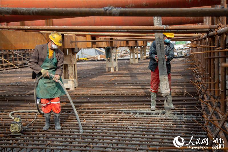 3月31日，施工人員在襄陽東西軸線魚梁洲隧道東津出口進行混凝土澆筑。（楊東 攝）