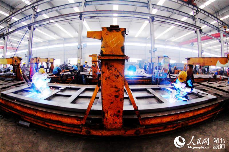 2020年4月2日，在湖北省十堰市鄖陽區茶店鎮神河集團生產車間，工人在生產線焊接作業。