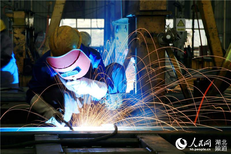 2020年4月2日，在湖北省十堰市鄖陽區茶店鎮神河集團生產車間，工人在生產線焊接作業。