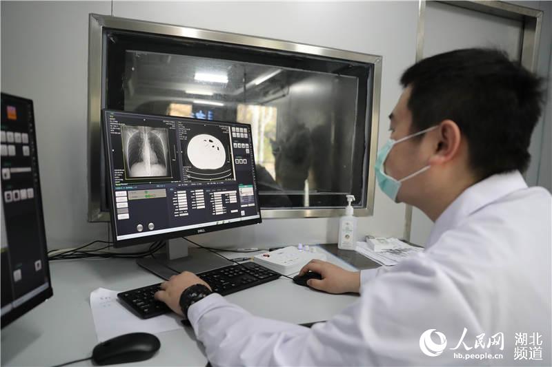 武漢科技大學醫院醫學影像科醫生錢琛在移動CT車上進行設備操作（攝影：張賓）
