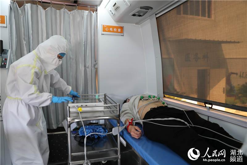 武漢科技大學醫院醫務人員在移動體檢車上進行心電圖檢查（攝影：張賓）