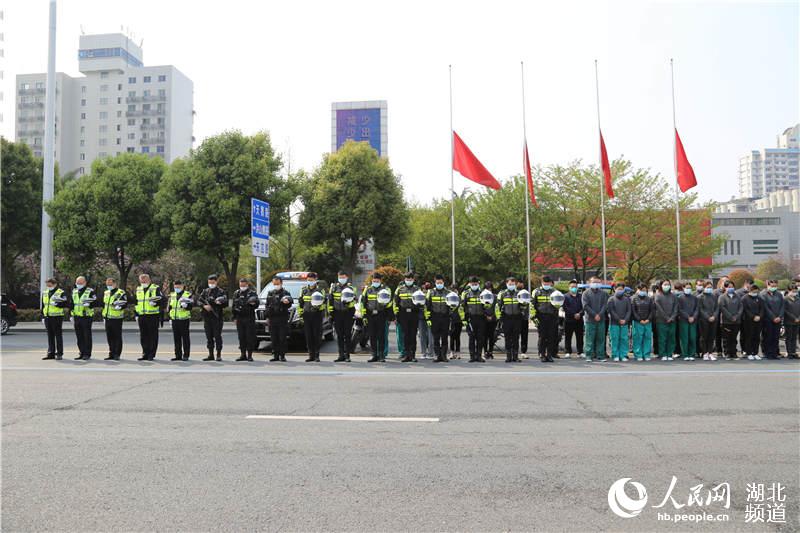 武漢市武昌區交通大隊民警與湖南支援湖北醫療隊一同在洪山禮堂前默哀。（高梓健 攝）