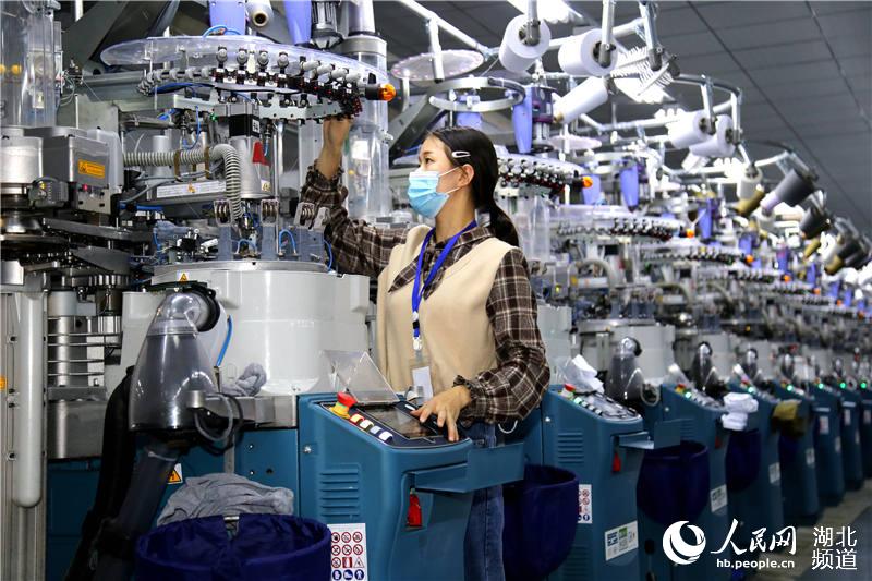 2020年4月10日，在湖北省十堰市鄖陽區楊溪鋪鎮青龍泉社區棉伙棉伴智能襪業扶貧車間，工人在智能襪機生產線上作業。