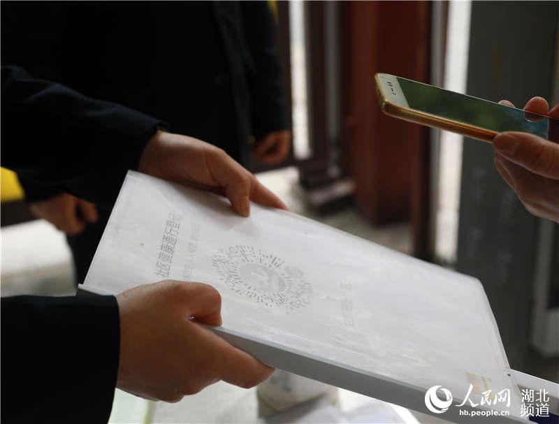 2020年4月13日，在武漢市武昌區站前陽光小區，居民正用手機掃碼登記出入。
