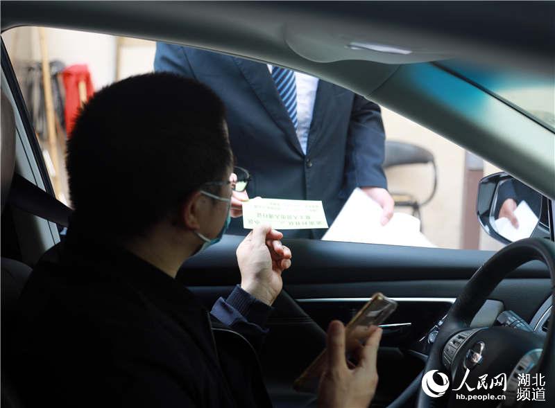 2020年4月13日，在武漢市武昌區站前陽光小區，物業人員做好復工人員出入通行証查驗登記工作。