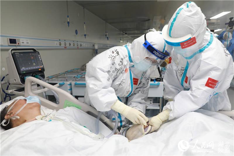 護士為患者做轉院前的最后一次護理（武漢大學中南醫院供圖）