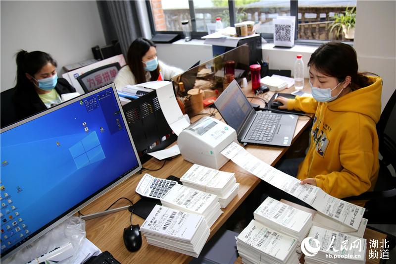 2020年4月14日，在湖北省十堰市鄖陽區電商服務中心，工作人員在打印網上訂單。