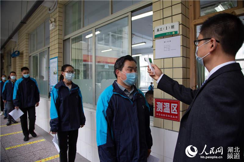 4月25日，在湖北省襄陽市第一中學，參加演練的高三年級老師在熟悉進入教室測量體溫環節。