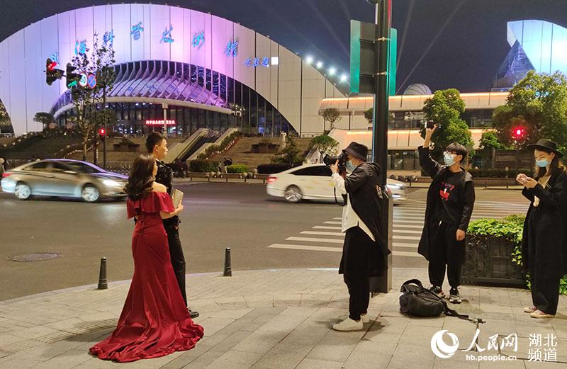 2020年4月27日晚，一對情侶在武漢科技館現代建筑前，拍攝婚紗照。