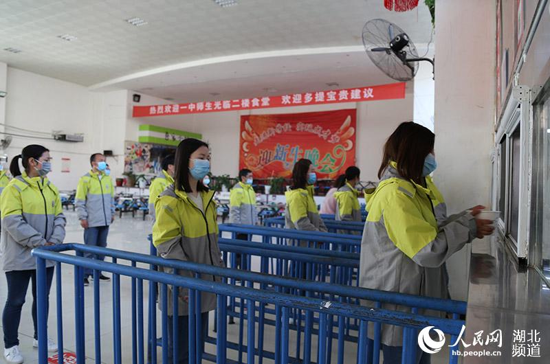 2020年4月27日，湖北省襄陽市保康縣第一中學參加模擬演練的教師模擬高三年級學生間隔一定距離進入食堂排隊取餐。