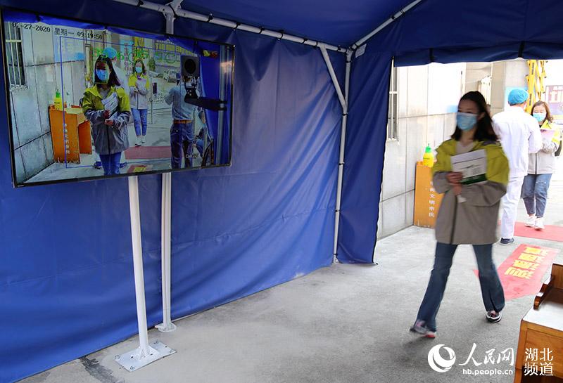 2020年4月27日，湖北省襄陽市保康縣第一中學參加模擬演練的教師模擬高三年級學生佩戴口罩，有序通過紅外熱成像測溫儀。