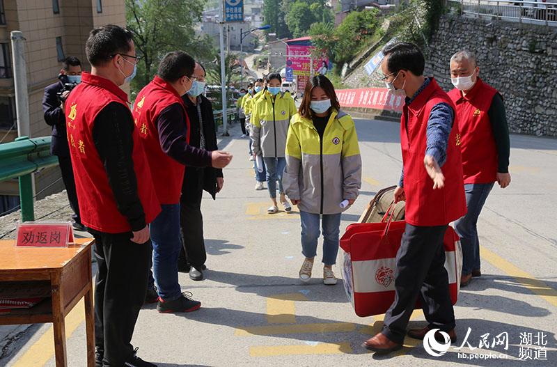 2020年4月27日，湖北省襄陽市保康縣第一中學參加模擬演練的教師模擬高三年級學生在教師的引導下，間隔一定距離排隊進入校園。