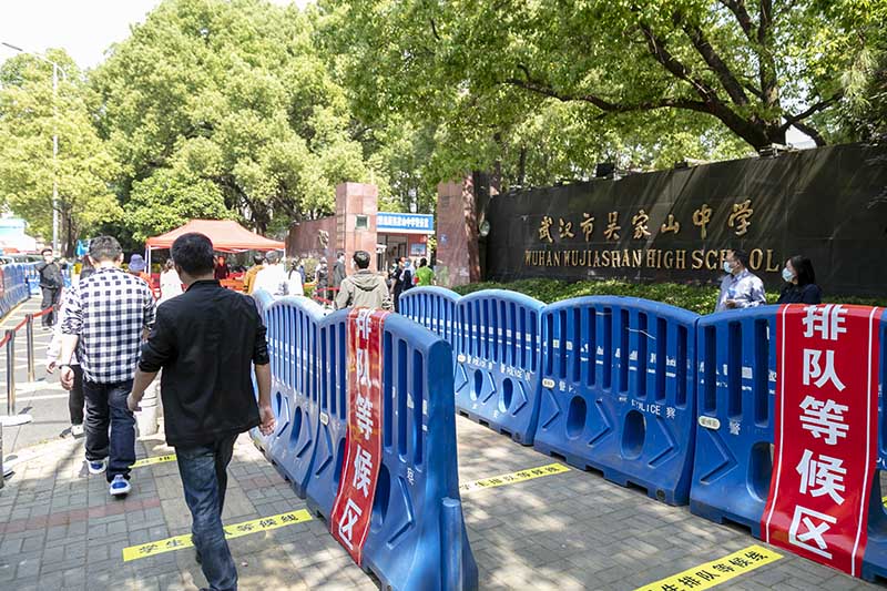 武漢市吳家山中學大門口被劃分成多個防控區域。王靜 攝