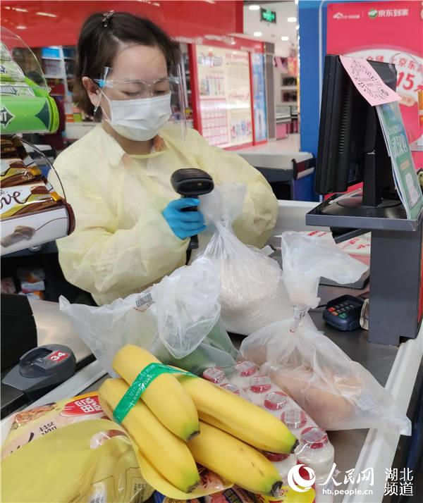 2020年4月29日上午，在武漢市中百倉儲唐家墩購物廣場，收款員戰疫防疫不放鬆，身穿防護服，堅守崗位，為民服務。