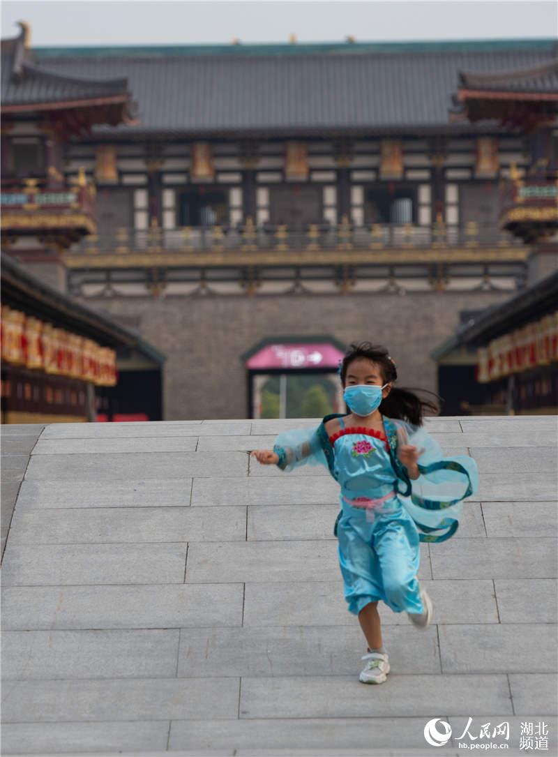 2020年5月1日，湖北省襄陽市，小游客身著古裝在襄陽唐城景區游覽，體驗穿越回唐朝的游玩體驗。