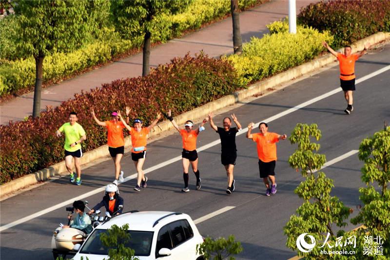 運動員在漢江北武濱江大道奔跑。