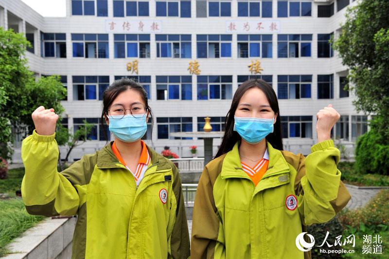 2020年5月6日，湖北省宜昌市夷陵區東湖高中高三學生向藝文（左）和蔡玉婷（右）在“復學第一課”上觀看疫情防控視頻“夷陵阻擊戰”后為自己高考加油。