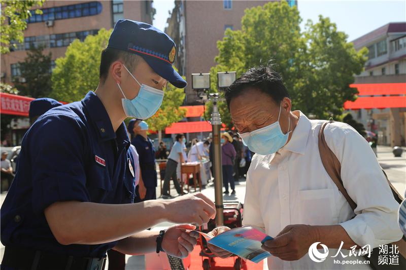 2020年5月12日，在湖北省黃岡市羅田縣人民廣場，消防員正在給群眾講解應急消防安全知識。（張光輝 攝）