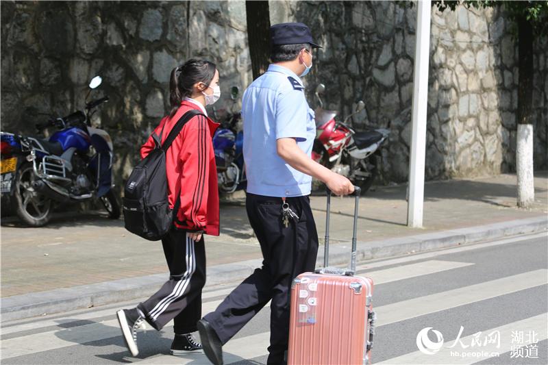 一名執勤警察幫學生推行李（何寶喜攝）