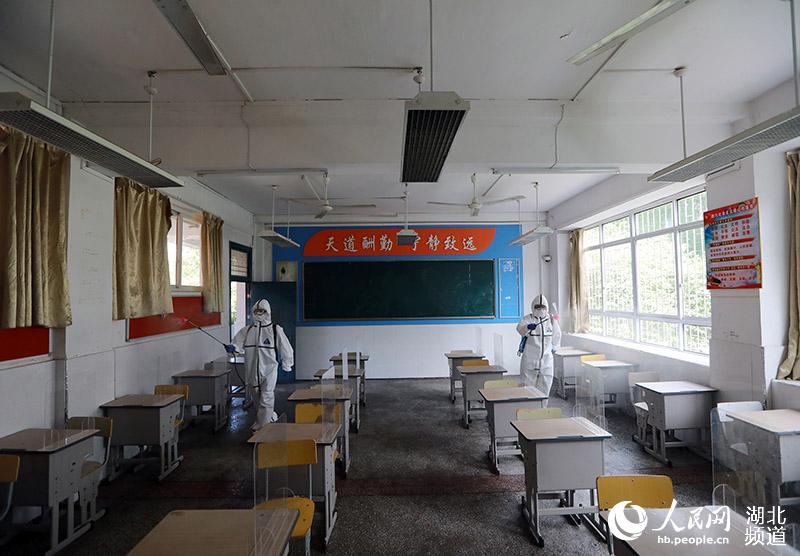 2020年5月19日，在湖北省武漢市糧道街中學，2名消防員正對上課教室進行全面消殺