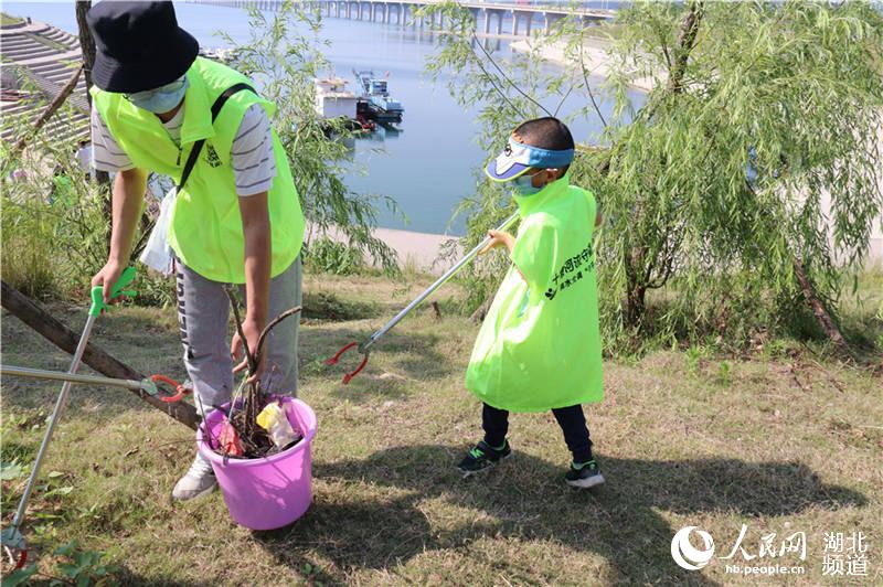 小學生在家長的帶領下參加巡河護水行動。