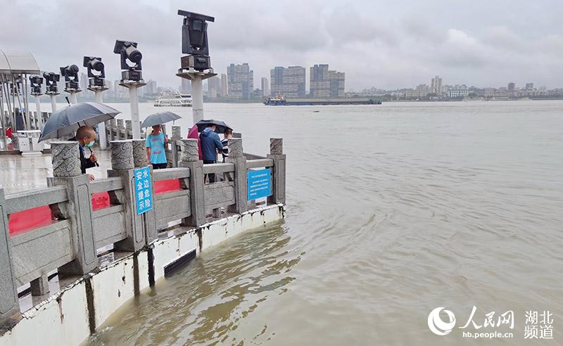 2020年7月5日下午，武漢市民冒雨在漢口龍王廟，觀察長江漢江兩江同時上漲的洪水。