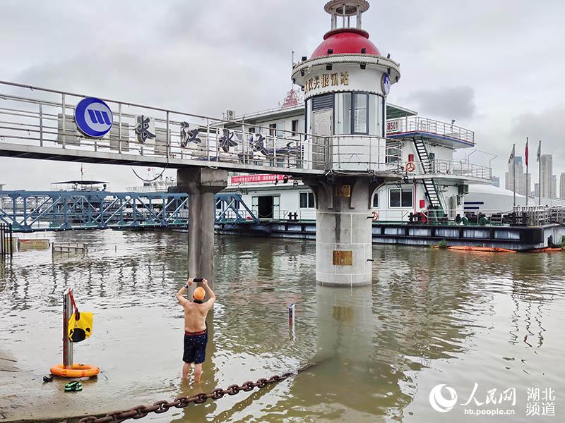 2020年7月5日下午，武漢市游泳愛好者冒雨在長江水文武漢關水位觀測點，拍攝觀察長江上漲的洪水。