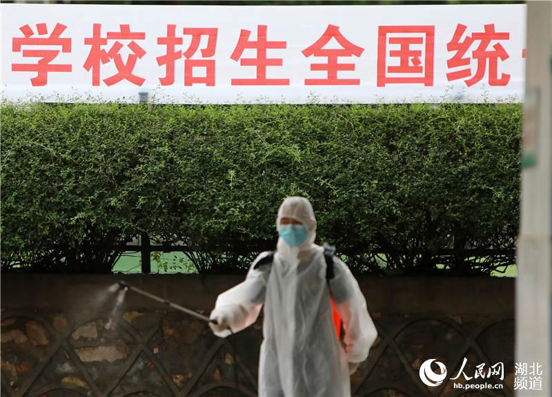2020年7月5日，在湖北省武漢市第二十三中學，1名消防員正在對高考考場外的公共衛生區域進行全面消殺